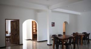 a dining room with a wooden table and chairs at Hotel Glee in Challi