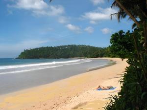 米瑞莎Coralworld Hotel的躺在海边的人