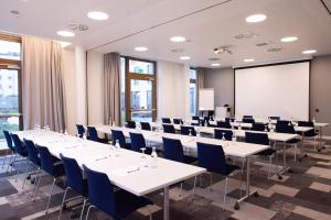 a conference room with tables and chairs and a whiteboard at Hampton By Hilton Stuttgart Airport in Filderstadt