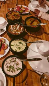 a table with many plates and bowls of food at Entire Farm house in Jim Corbett with staff and cook in Rāmnagar