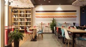 Un restaurante con mesas y sillas en una sala. en ibis Xian South Gate, en Xi'an