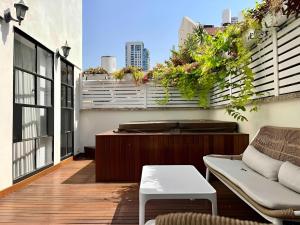 ein Balkon mit einer Couch und einem Tisch auf einem Gebäude in der Unterkunft The TownHouse - Neve Zedek in Tel Aviv
