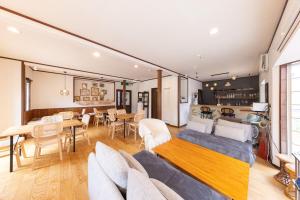 ein Wohnzimmer mit Sofa und Tisch in der Unterkunft Forest and Stars Akakura Lodge in Myōkō