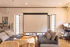 ein Wohnzimmer mit einem großen Bildschirm in der Wand in der Unterkunft Forest and Stars Akakura Lodge in Myōkō