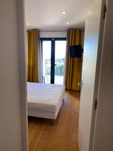 a bedroom with a white bed and a window at Chambre Shelby vue mer avec kitchenette in Porto-Vecchio