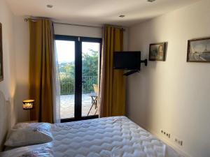 a bedroom with a bed and a sliding glass door at Chambre Shelby vue mer avec kitchenette in Porto-Vecchio