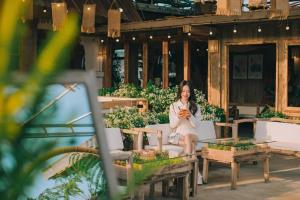 Ấp Kim ThạchDa Lat Cam Ly Hotel的坐在庭院沙发上的女人