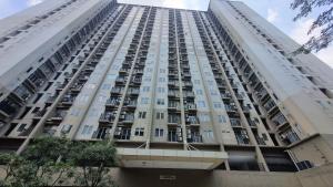 OYO 95052 Cordia Tower في Tjikuda Dua: مبنى أبيض طويل مع العديد من النوافذ