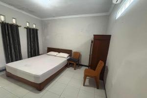 Un pat sau paturi într-o cameră la OYO 95050 Penginapan Sekarsari Syariah