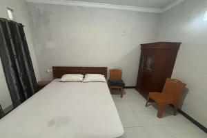 Un pat sau paturi într-o cameră la OYO 95050 Penginapan Sekarsari Syariah +16 fotografii