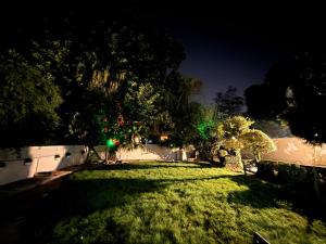 a yard at night with a fence and green lights at Islamabad Pak Palace guest house in Islamabad