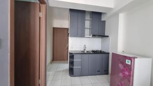 OYO 95052 Cordia Tower في Tjikuda Dua: مطبخ صغير مع حوض وموقد