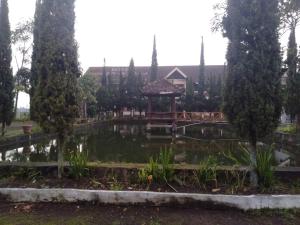 un jardín con un cenador y un estanque en OYO 95039 Hotel Agung Permata Artha, en Bojongsalam