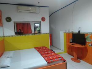 1 dormitorio con 1 cama, TV y espejo en OYO 95039 Hotel Agung Permata Artha, en Bojongsalam 16 fotos más