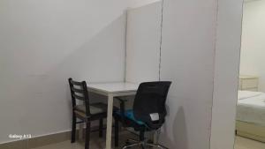 a room with a table and two chairs and a bed at Cyberjaya Studio Suite By NSB in Cyberjaya