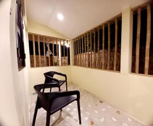 斯里曼加尔乌帕齐拉Jolpoddo Retreat的两把黑椅子坐在窗户的房间