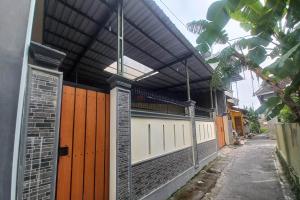 a building with a gate and a fence at OYO 95058 Agago Homestay Syariah in Kedungtengkong