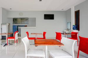 a dining room with red chairs and a table at OYO 95058 Agago Homestay Syariah in Kedungtengkong