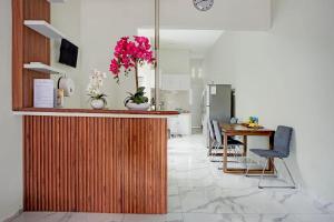 a kitchen with a counter with a table and a kitchen with a refrigerator at OYO 95054 Prima Jaya Homestay Syariah in Kedungtengkong