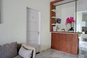 a living room with a couch and a mirror at OYO 95054 Prima Jaya Homestay Syariah in Kedungtengkong
