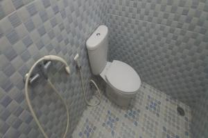 a bathroom with a white toilet in a wall at OYO 95054 Prima Jaya Homestay Syariah in Kedungtengkong +16 photos