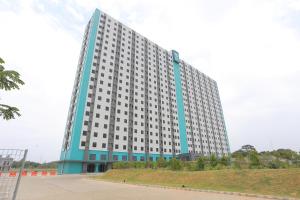 un gran edificio azul y blanco en Capital O 95049 Aurora Rooms @ Riverdale, en Tanahbaru