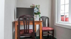 un tavolo con due sedie e una televisione sopra di Baymont by Wyndham Lake George a Lake George