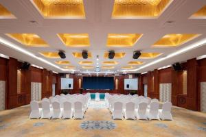 义乌Yiwu Yimei Plaza Hotel的一间会议室,配有白色的椅子和屏幕