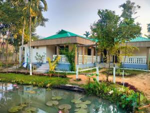 斯里曼加尔乌帕齐拉Jolpoddo Retreat的前面有池塘的房子