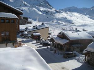 a town with snow covered buildings and a mountain at Temples du Soleil Machu Appartements VTI in Val Thorens