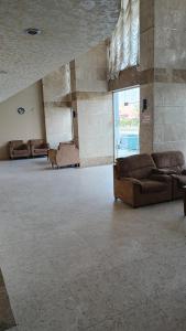 un grand salon avec des canapés et une grande fenêtre dans l'établissement الرحابة المكية الفندقية, à Al Masfalah