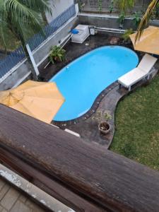 an overhead view of a swimming pool with two umbrellas at A few steps from the beach in Pereybere