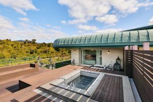 a house with a deck with a swimming pool at Grand Josun Jeju in Seogwipo