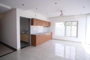 a kitchen with wooden cabinets and a large window at 69th Heaven Hotel in Devanhalli