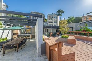 eine Terrasse mit Tischen und Stühlen und einem Sonnenschirm in der Unterkunft Luxo na Gloria in Rio de Janeiro