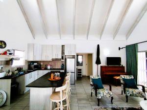 a kitchen with a table and chairs in a room at Mosseltjie - Self Catering in Britannia Bay