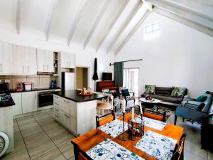 a kitchen and living room with a table and chairs at Mosseltjie - Self Catering in Britannia Bay