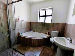 a bathroom with a tub and a toilet and a sink at Mosseltjie - Self Catering in Britannia Bay +15 photos