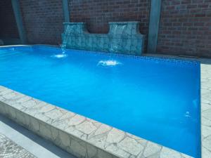 a large blue swimming pool with a water fountain at El Valle - Lunahuaná in Lunahuaná