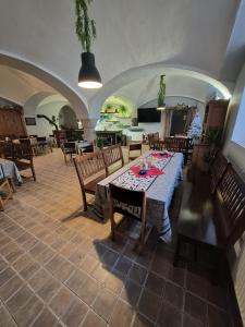 a dining room with a table and chairs and a kitchen at Hostinec Lovecký zámeček in Olešnice v Orlických horách +21 photos