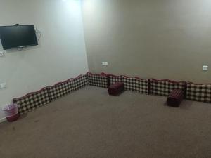 an empty room with chairs and a flat screen tv at الرحابة المكية الفندقية in Al Masfalah