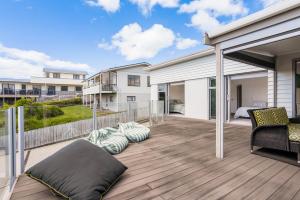a deck with a bed and pillows on it at Peaceful Paradise - Waihi Beach Holiday Home in Waihi Beach