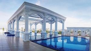 ein großes weißes Gebäude mit einem Pool in der Unterkunft Adimulia Hotel Medan in Medan