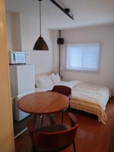 a room with a bed and a table and a bed at 大泉学園 練馬の家灯 池袋まで15分 としまえん 吉祥寺 飯能 観光に in Yagisawa