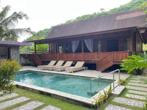 a house with a pool and a deck with lounge chairs at Villa D'La Madeira in Mantang