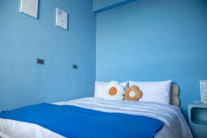 a blue bedroom with two stuffed animals on a bed at Wumu B&B in Hengchun South Gate
