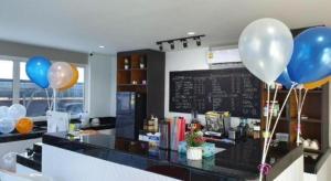 a counter with balloons in a restaurant with a chalkboard at PJ PLACE in Ban Bang Samak