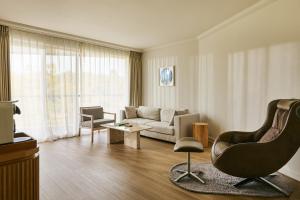 a living room with a couch and a chair at Grand Josun Jeju in Seogwipo