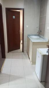 une salle de bain avec un lavabo et des toilettes et une porte dans l'établissement الرحابة المكية الفندقية, à Al Masfalah