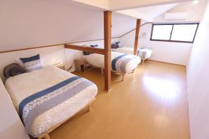 a bedroom with two beds in a room with a window at Forest and Stars Akakura Sauna in Myoko